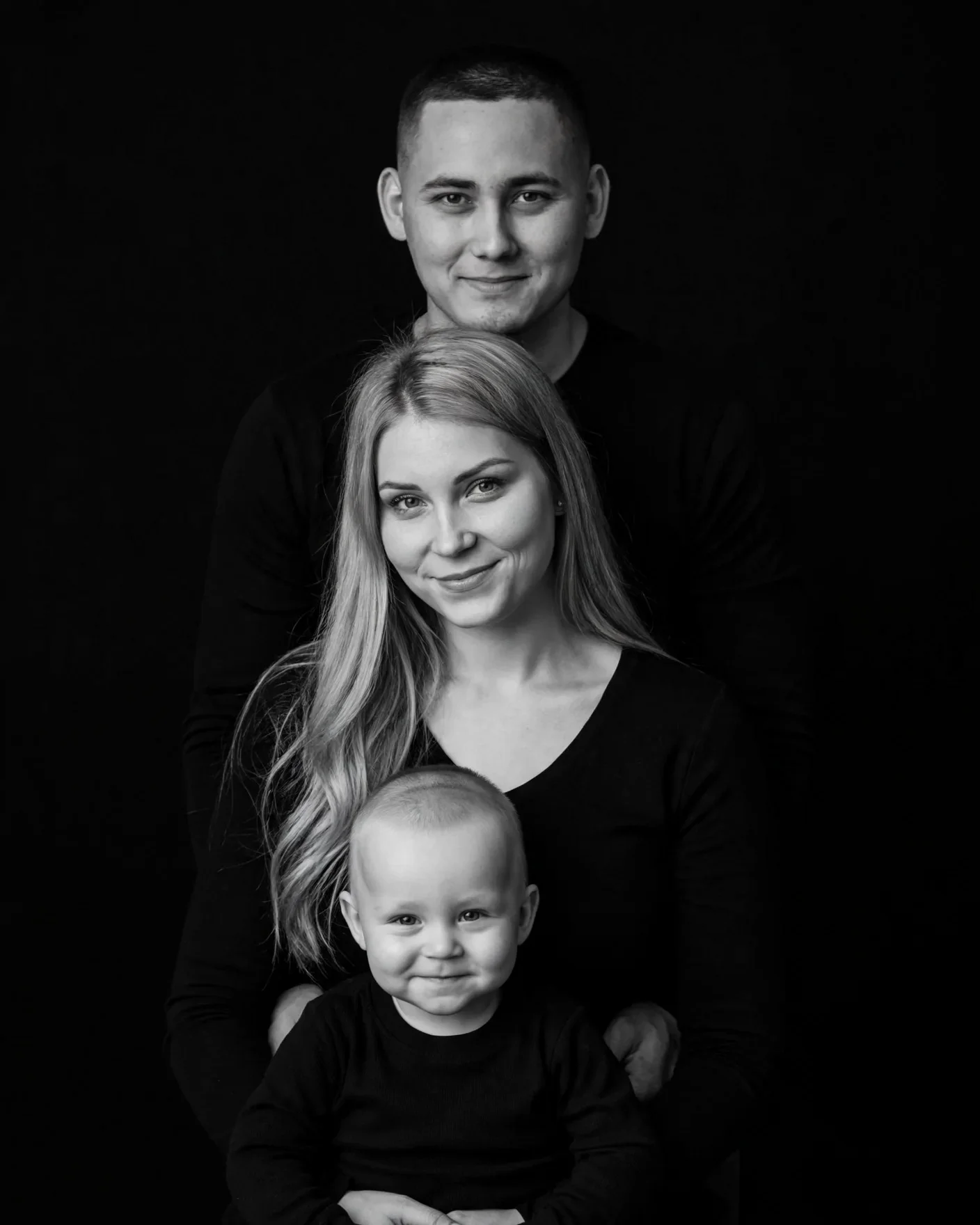 Семейный черно-белый фото портрет родителей с ребенком на черном фоне